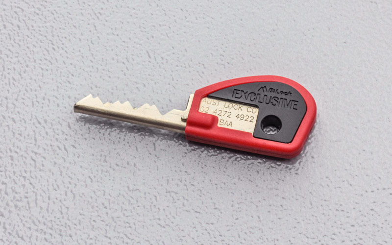 Close up of restricted key with red grip on grey background